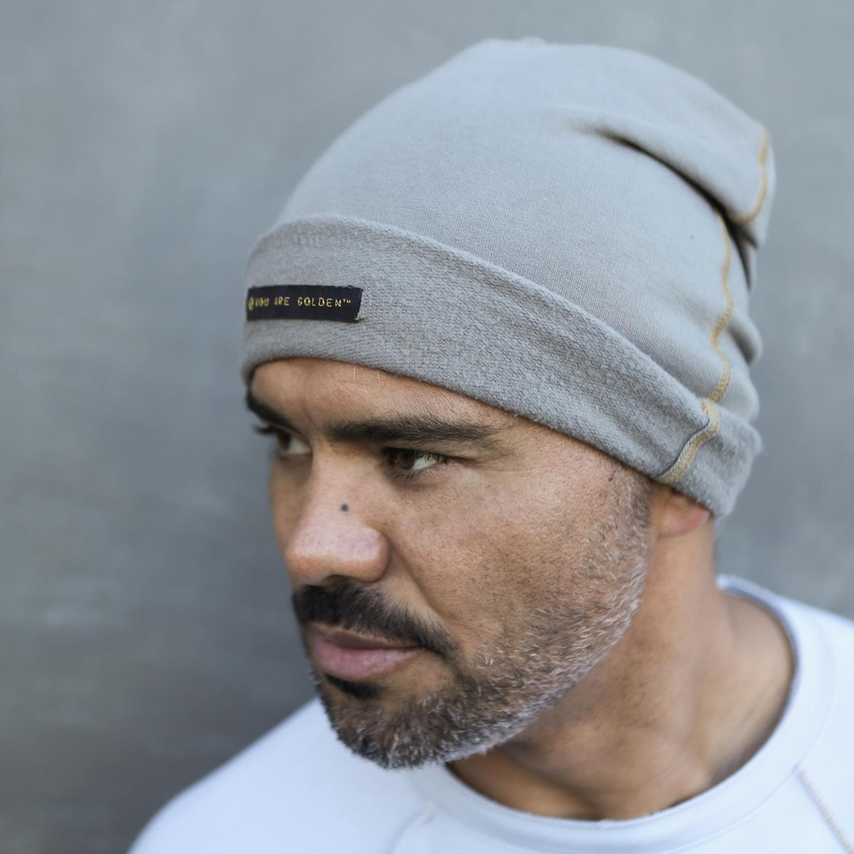 A man modeling the One Golden Thread OG Cloud Beanie in Shroom