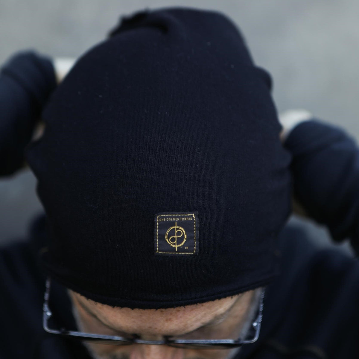 A man modeling the One Golden Thread OG Cloud Beanie in Black