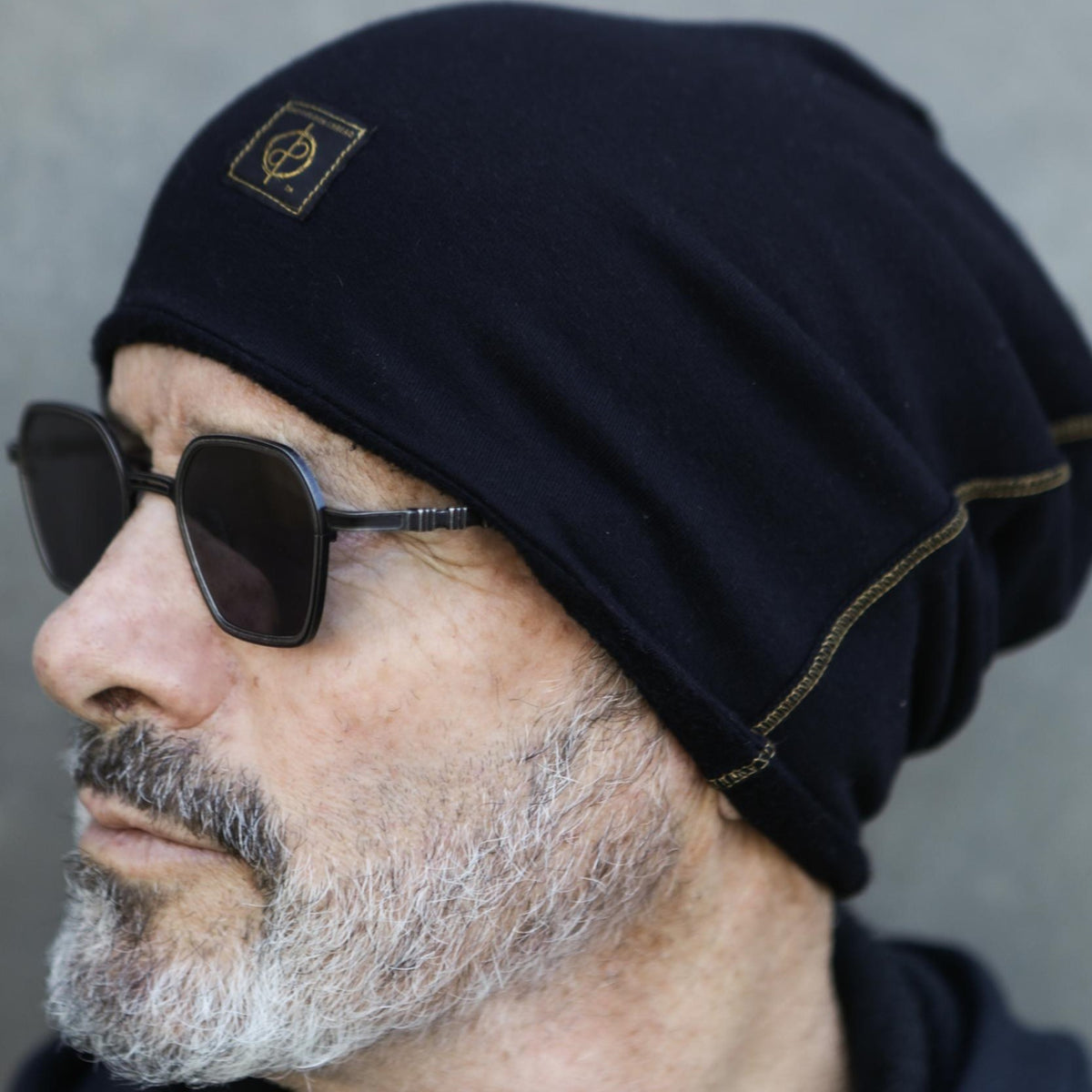 A man modeling the One Golden Thread OG Cloud Beanie in Black