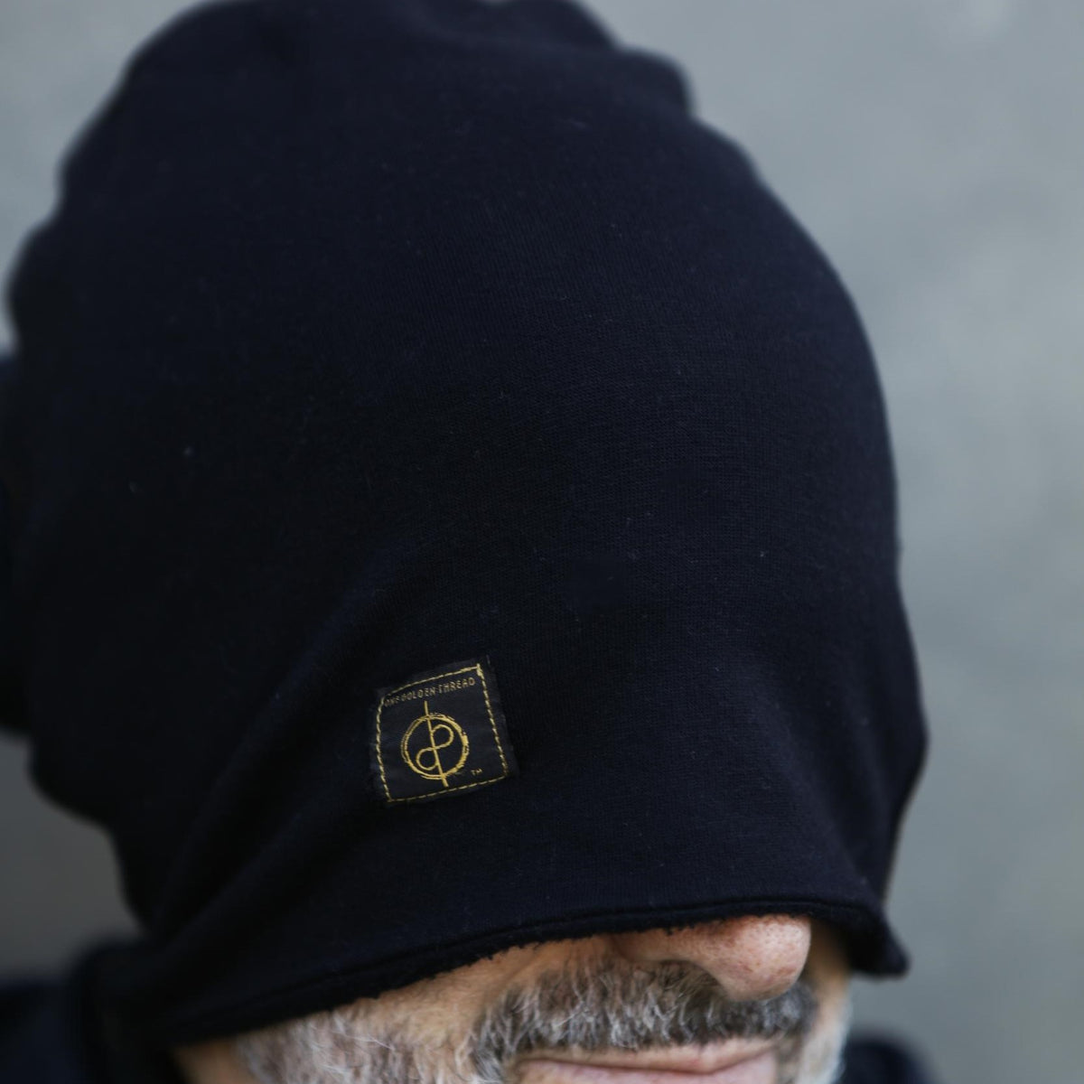 A man modeling the One Golden Thread OG Cloud Beanie in Black