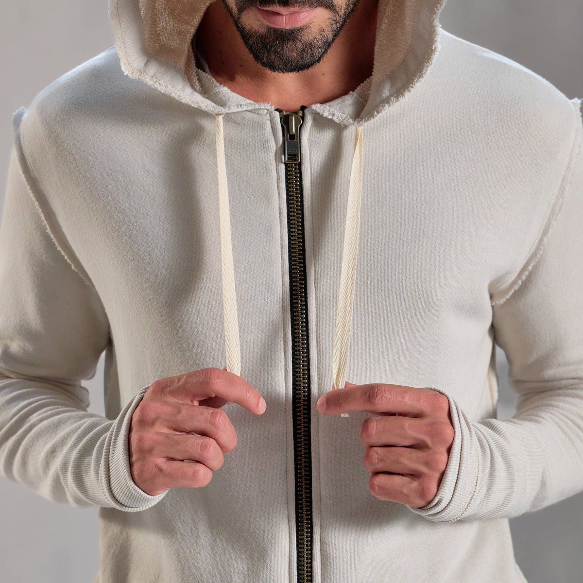 Man modeling a white stone hoodie 