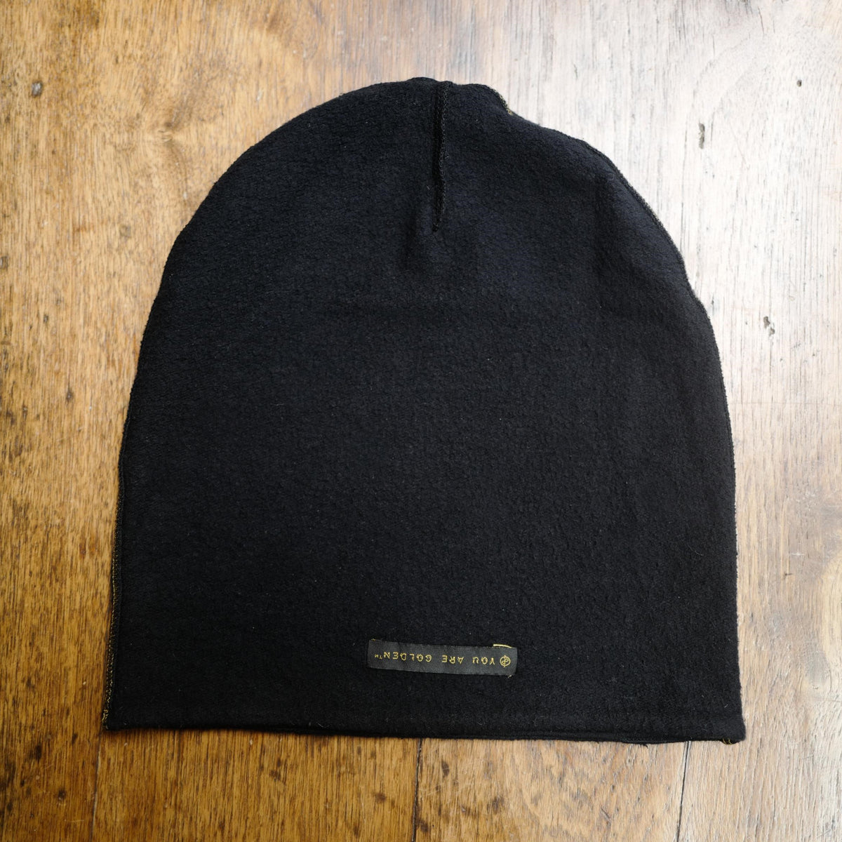 The One Golden Thread OG Cloud Beanie in Black with the saying "You are golden"