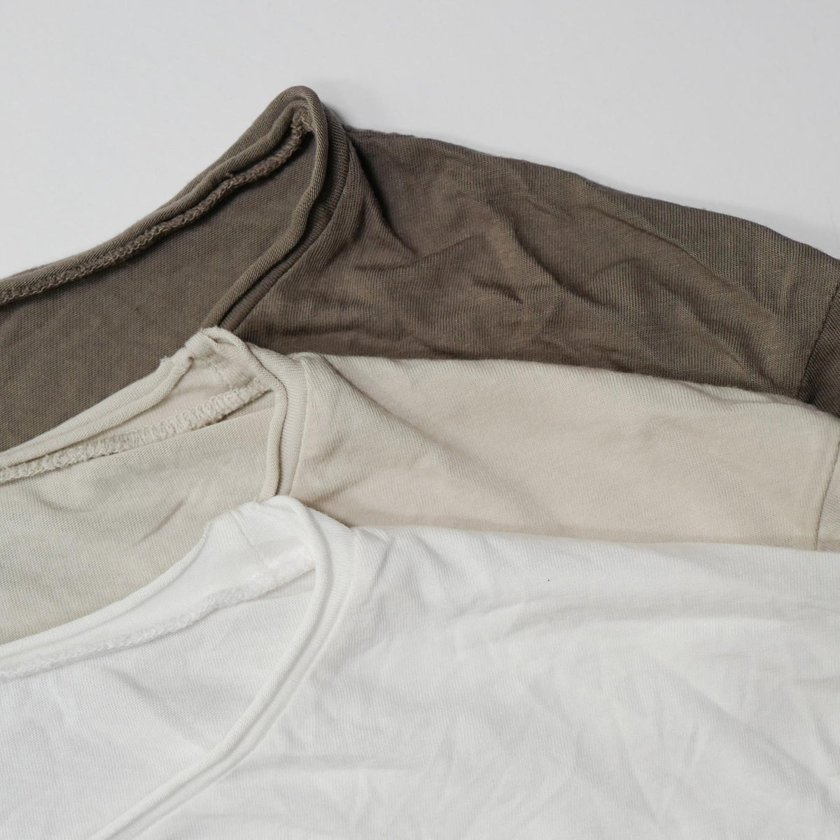 Flat lay of three crew neck shirts in different colors
