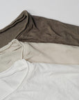 Flat lay of three crew neck shirts in different colors