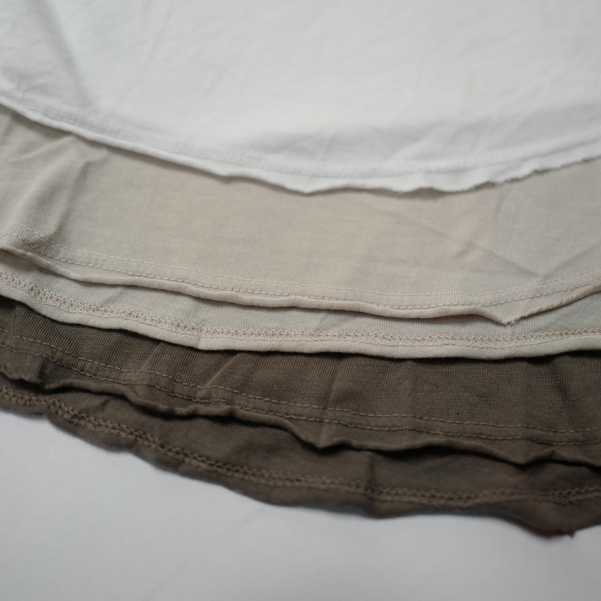 Flat lay of three crew neck shirts in different colors