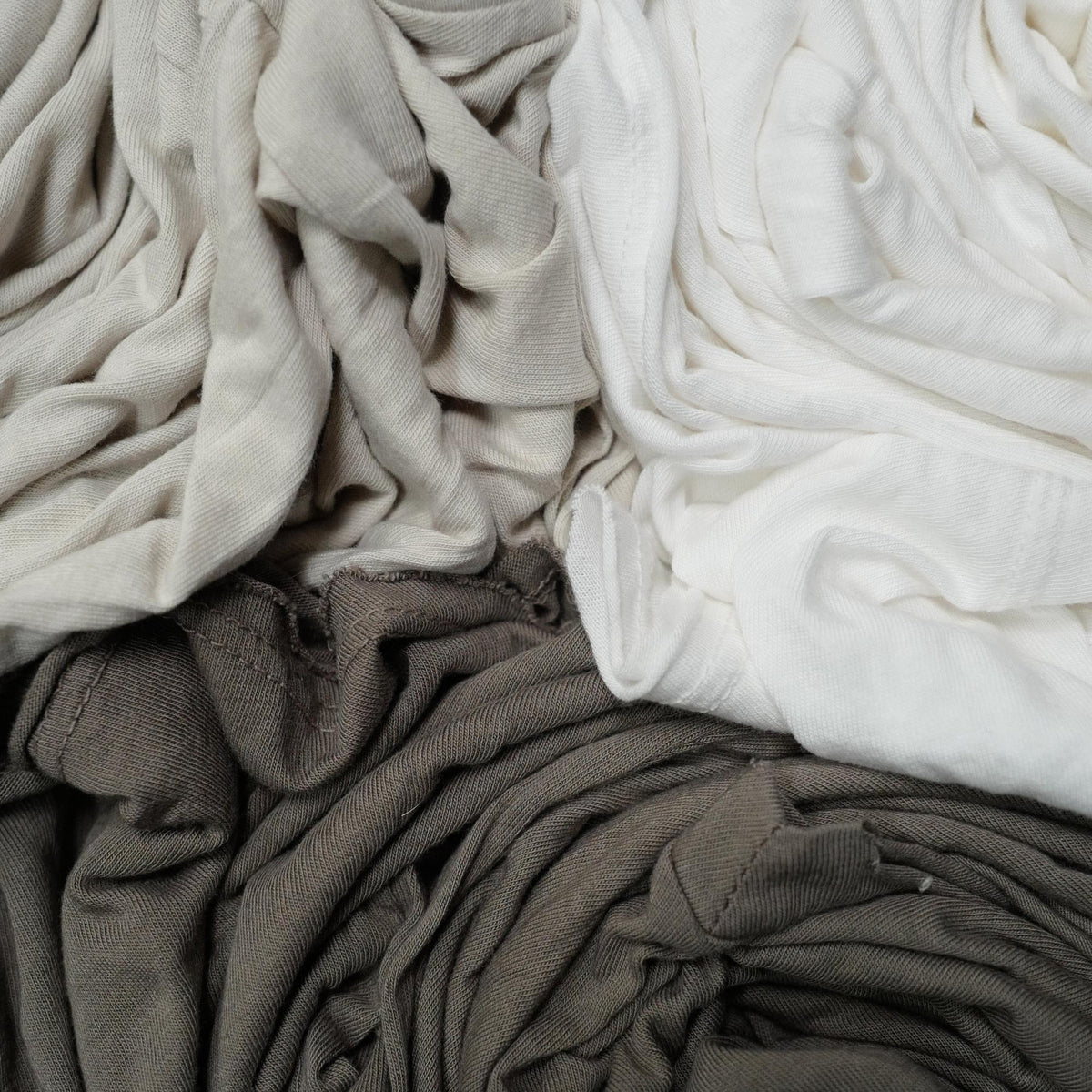 Flat lay of three crew neck shirts in different colors