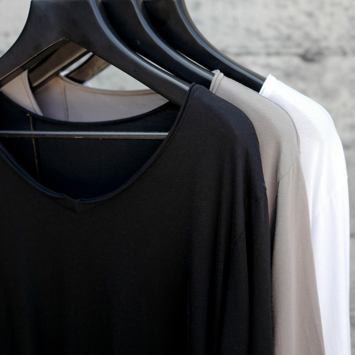 Different colored v neck three pack on clothing racks