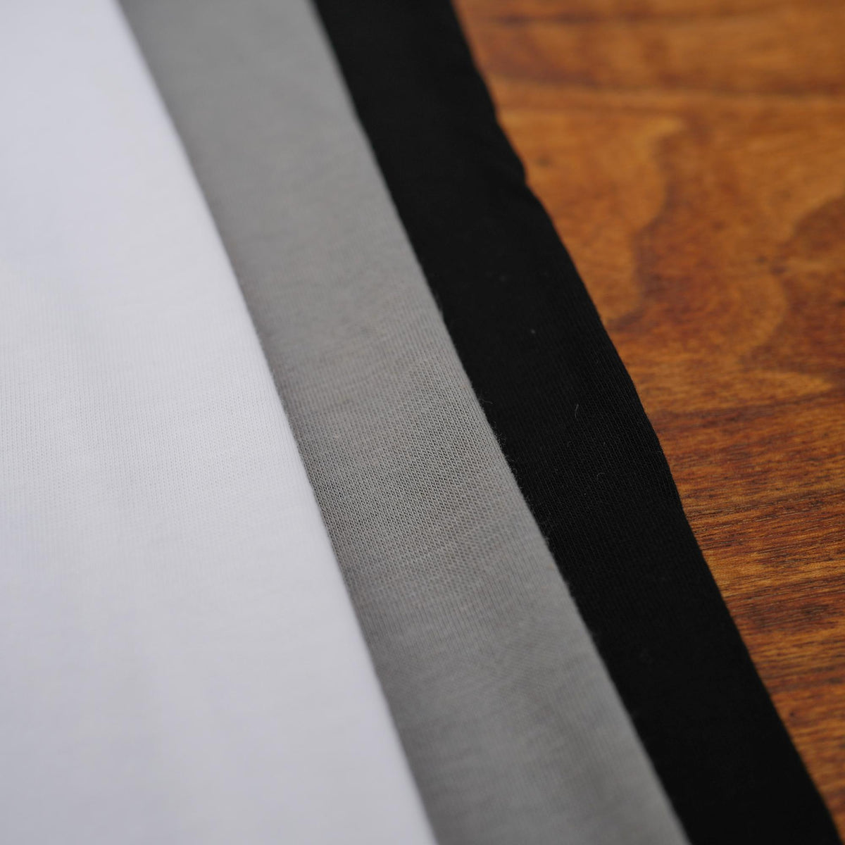 Flat lay of ultimate tee three pack in different colors
