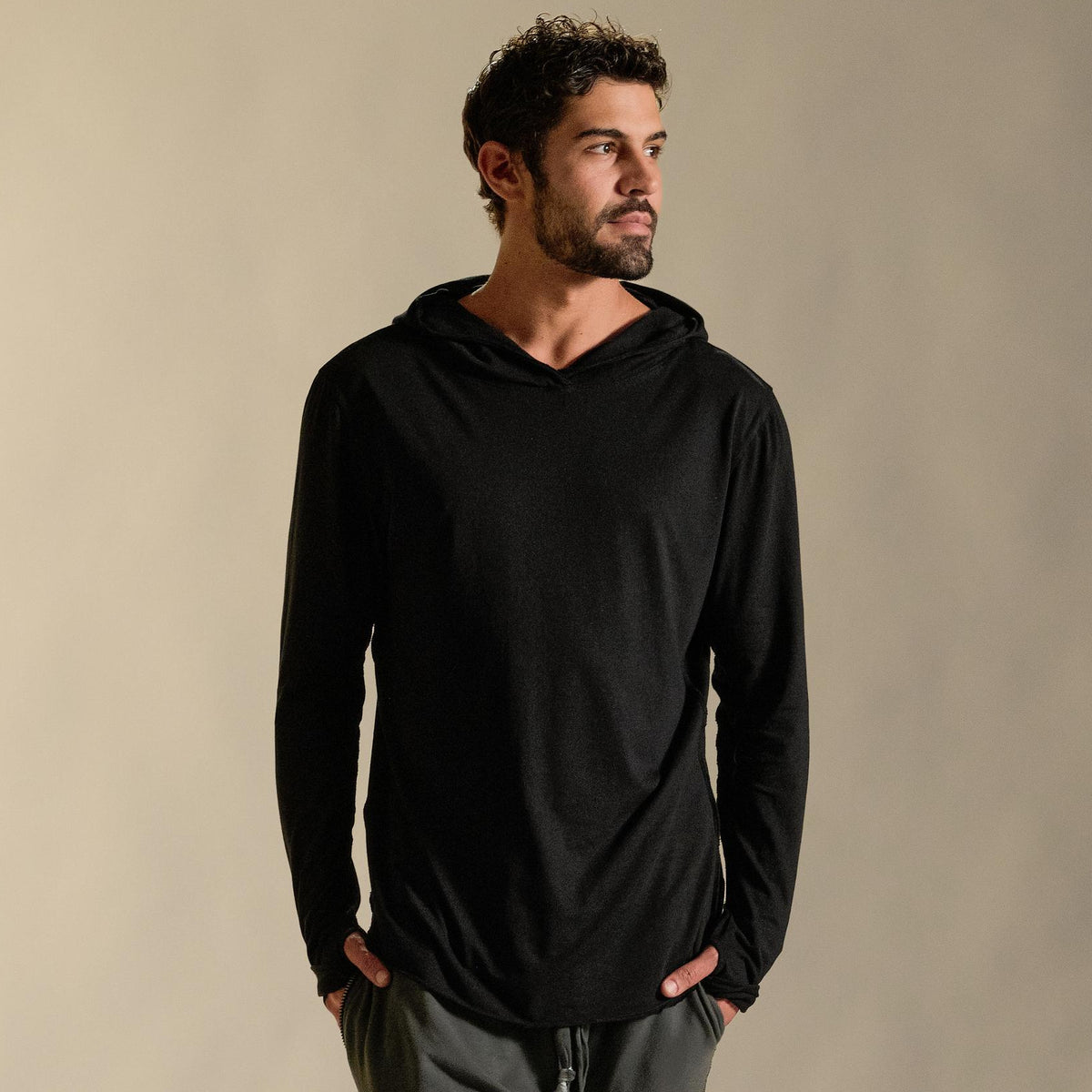 Man modeling black long-sleeve hooded tee