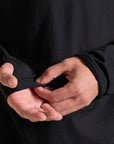 Man modeling black long-sleeve hooded tee