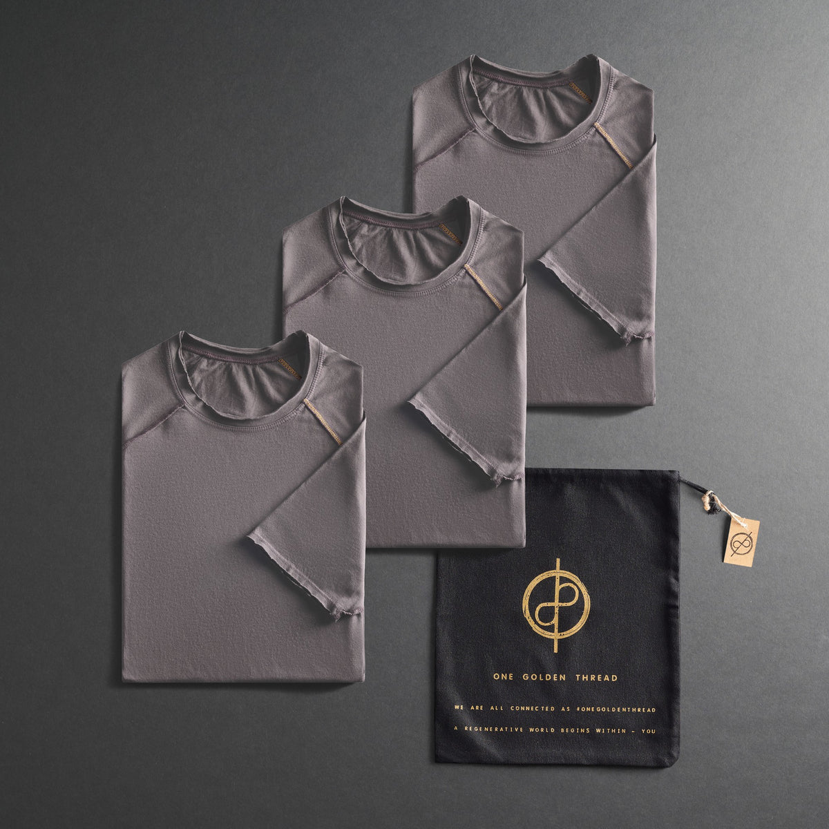 three folded gray shirts on a dark gray background