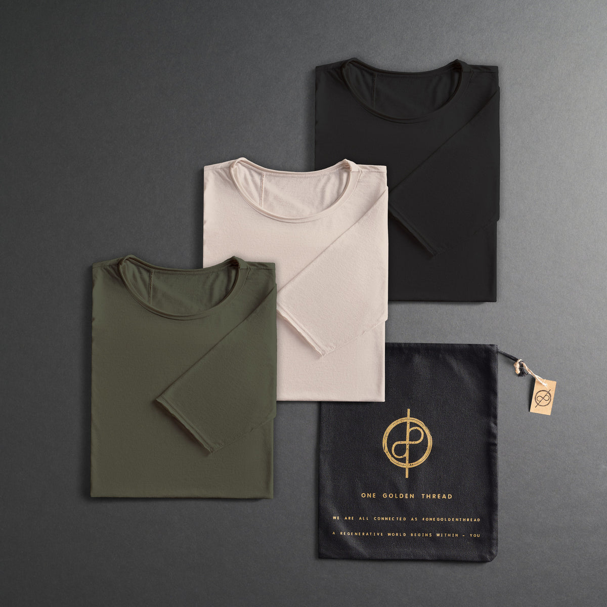 three folded shirts in different colors on a dark gray background