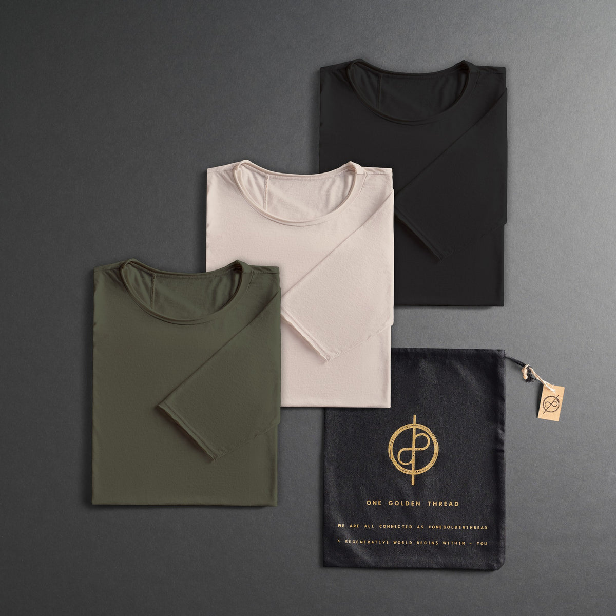 three folded shirts in different colors on a dark gray background