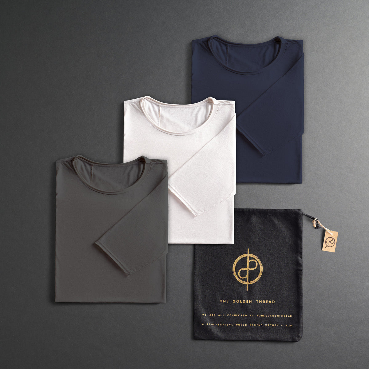 three folded shirts in different colors on a dark gray background