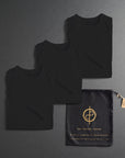 three folded shirts in black on a dark gray background
