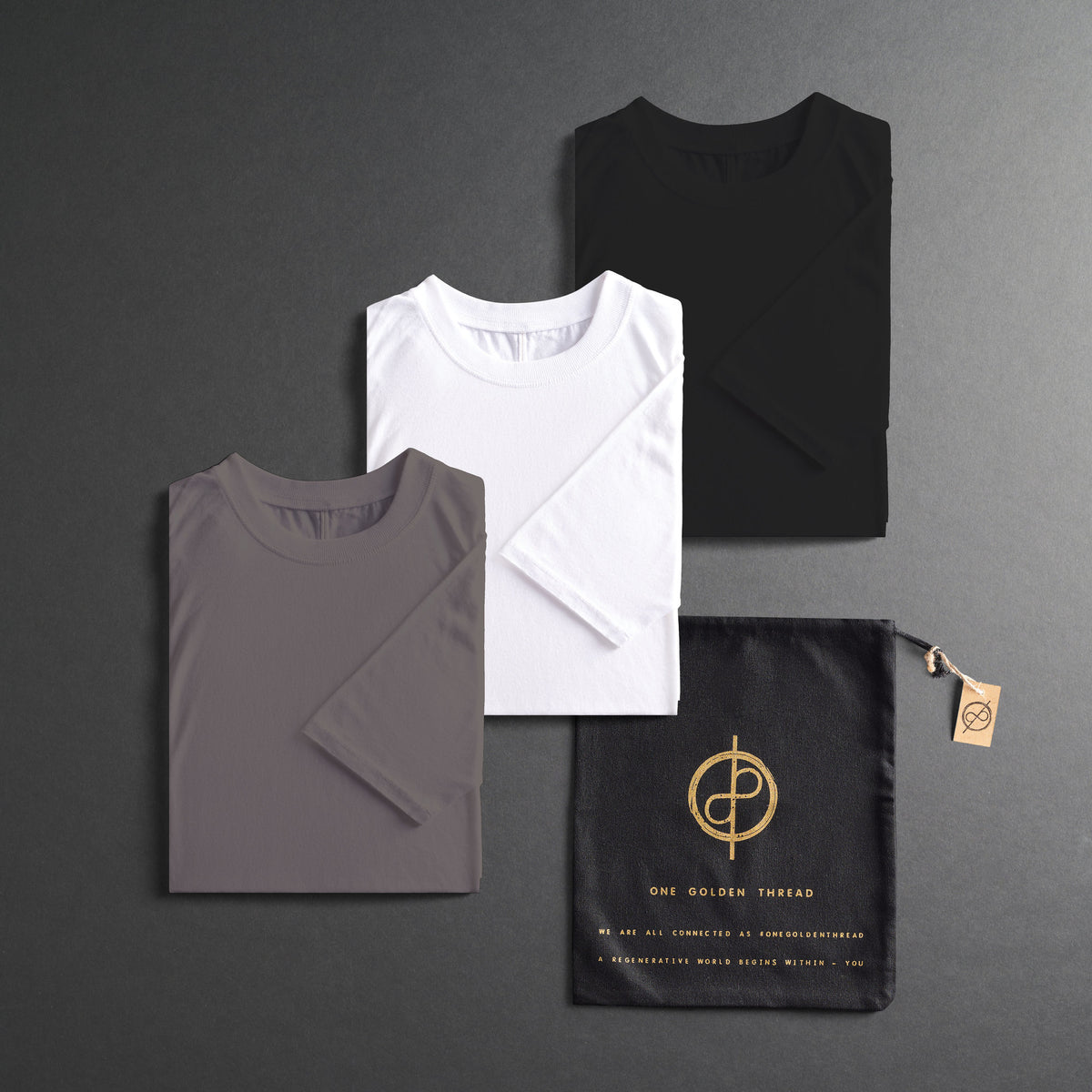 three folded shirts in different colors on a dark gray background