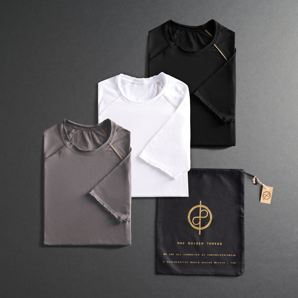 three folded shirts in different colors on a dark gray background