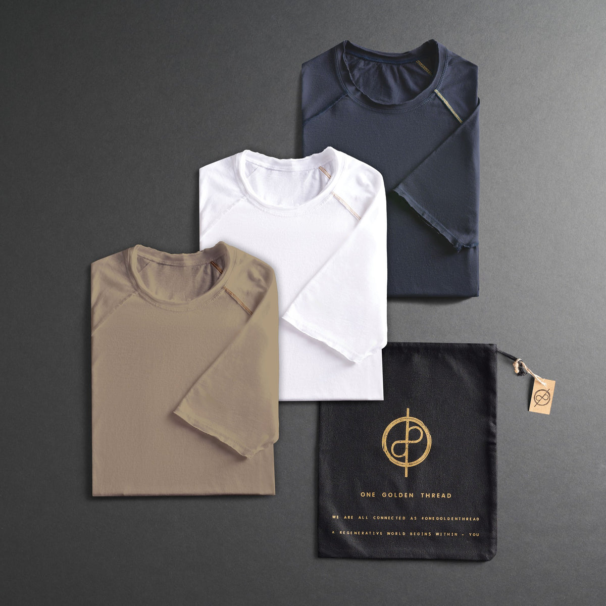 three folded shirts in different colors on a dark gray background
