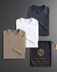 three folded shirts in different colors on a dark gray background