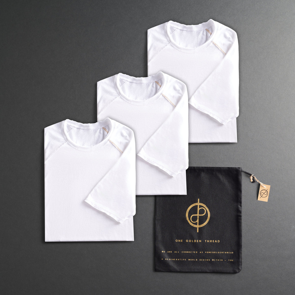 three folded white shirts on a dark gray background