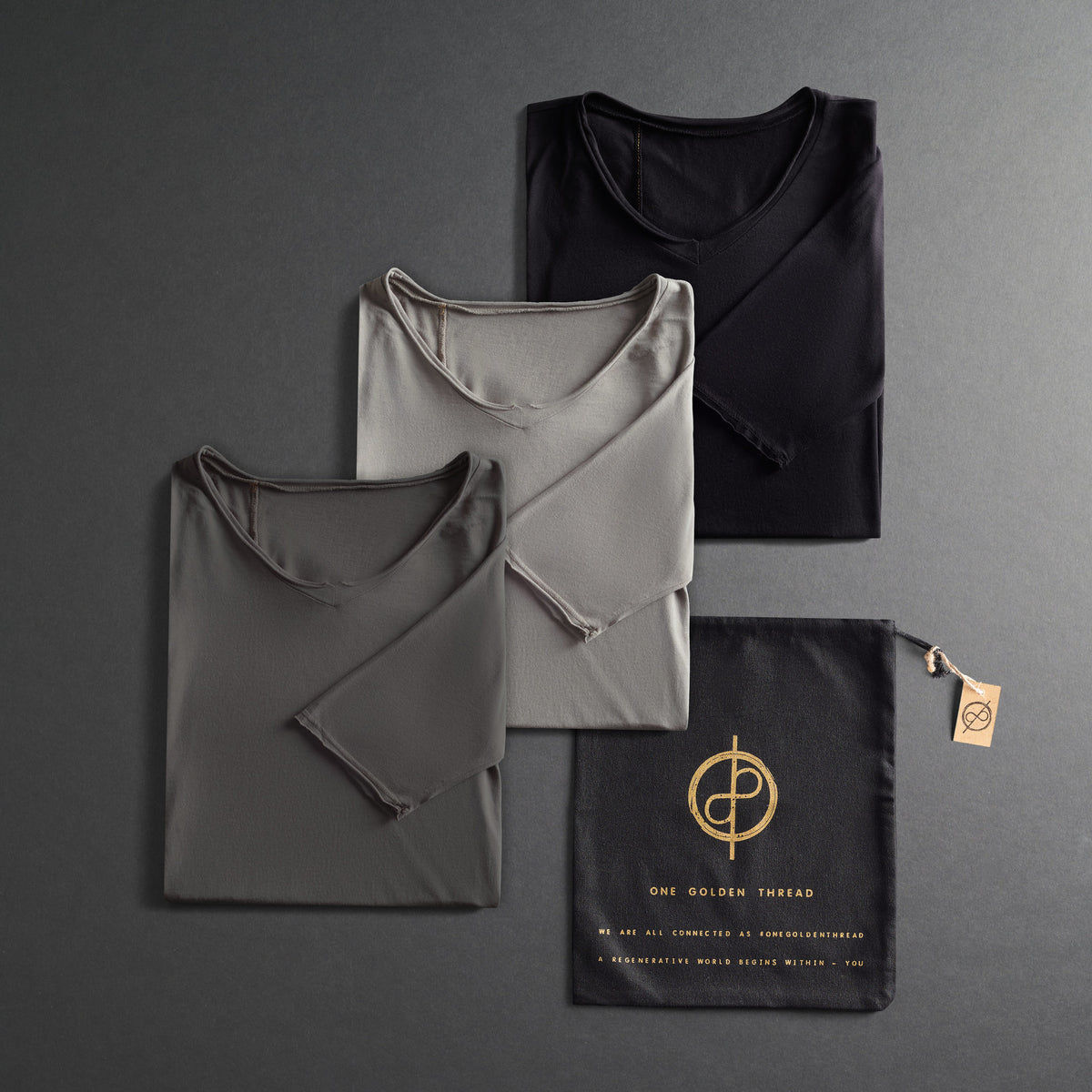 three folded shirts in different colors on a dark gray background