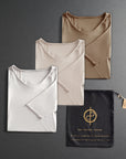 three folded shirts in different colors on a dark gray background