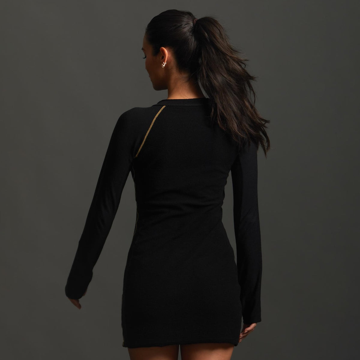 A woman modeling the One Golden Thread Reversible Little Black Dress