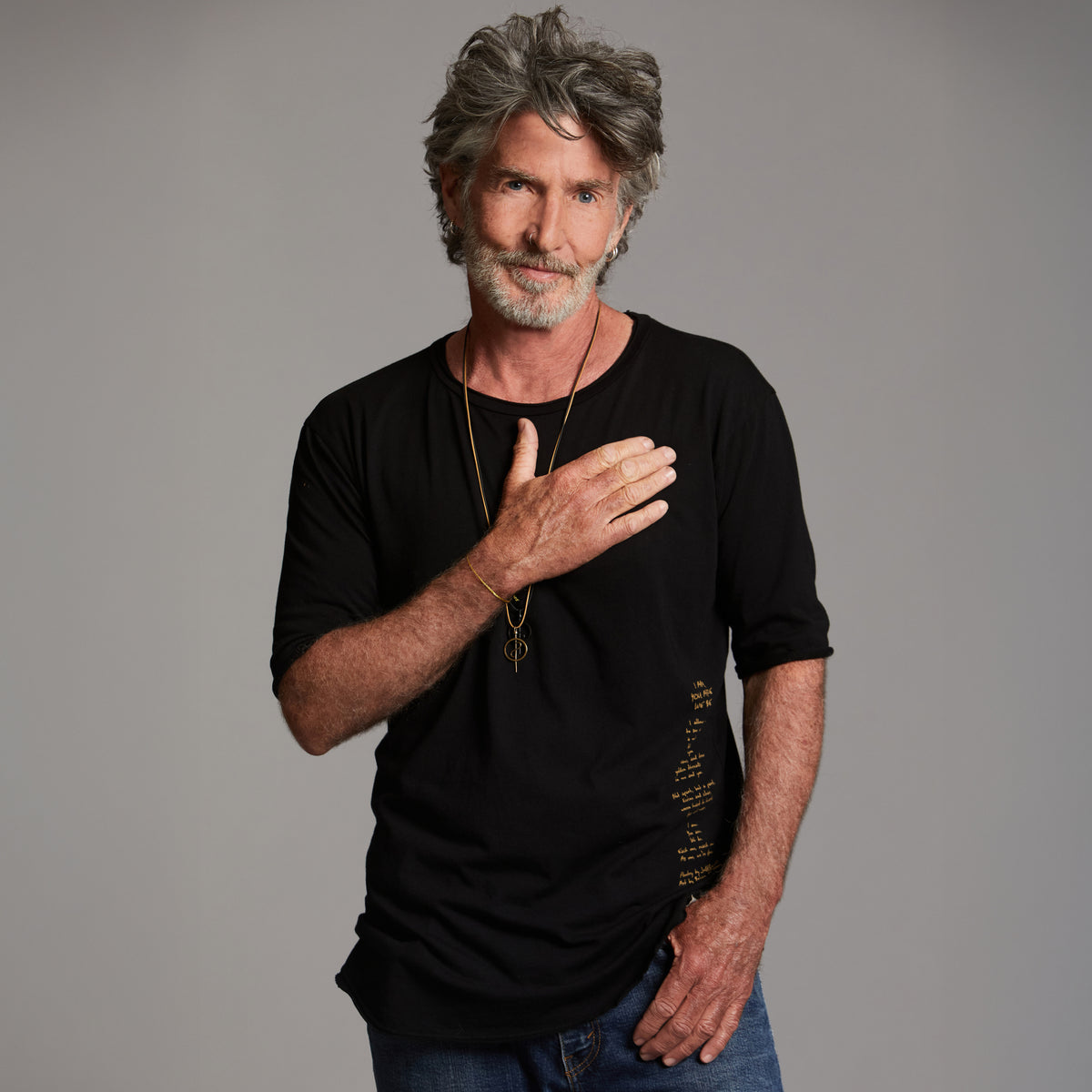 Man modeling a crew neck t shirt with gold graphics