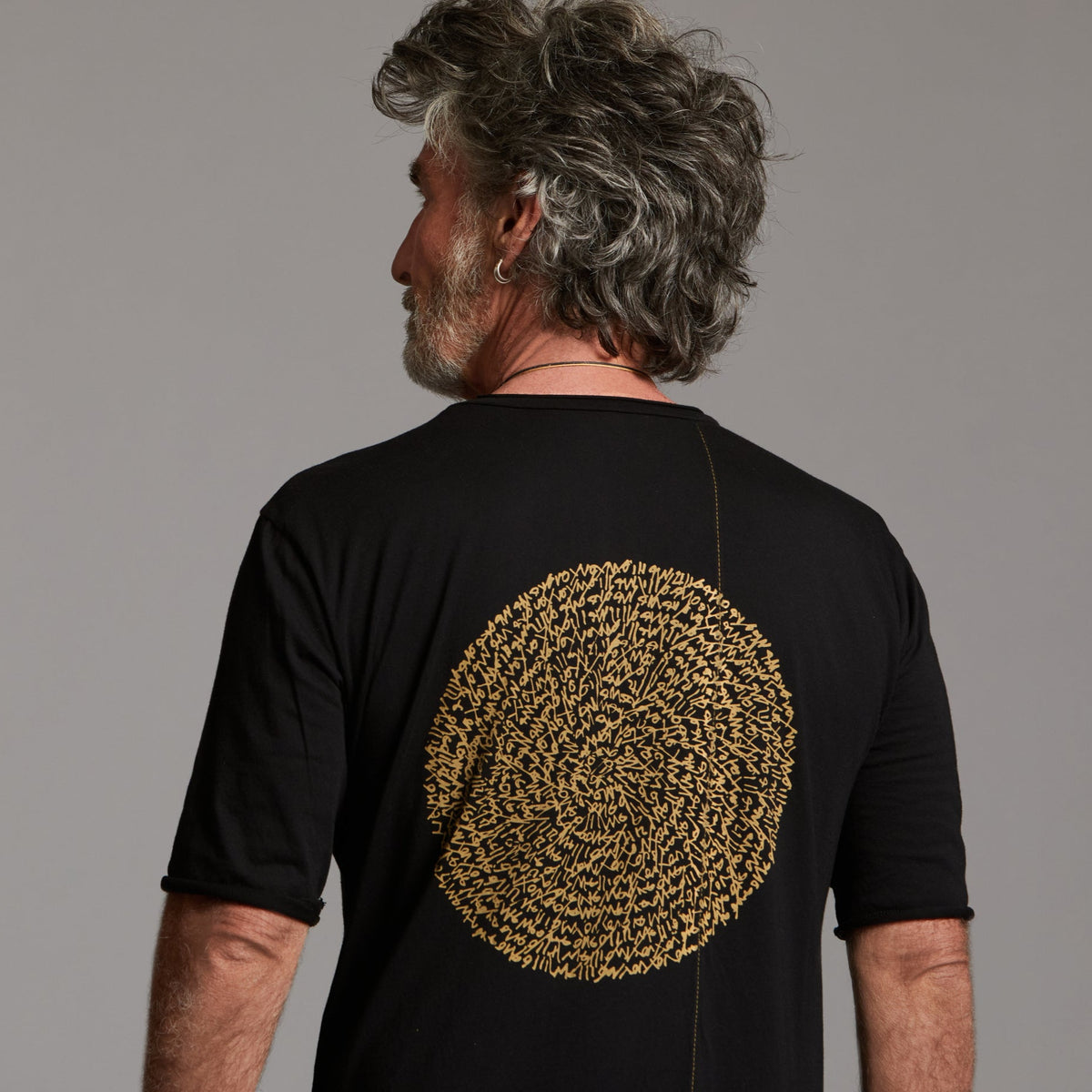 Man modeling a crew neck t shirt with gold graphics