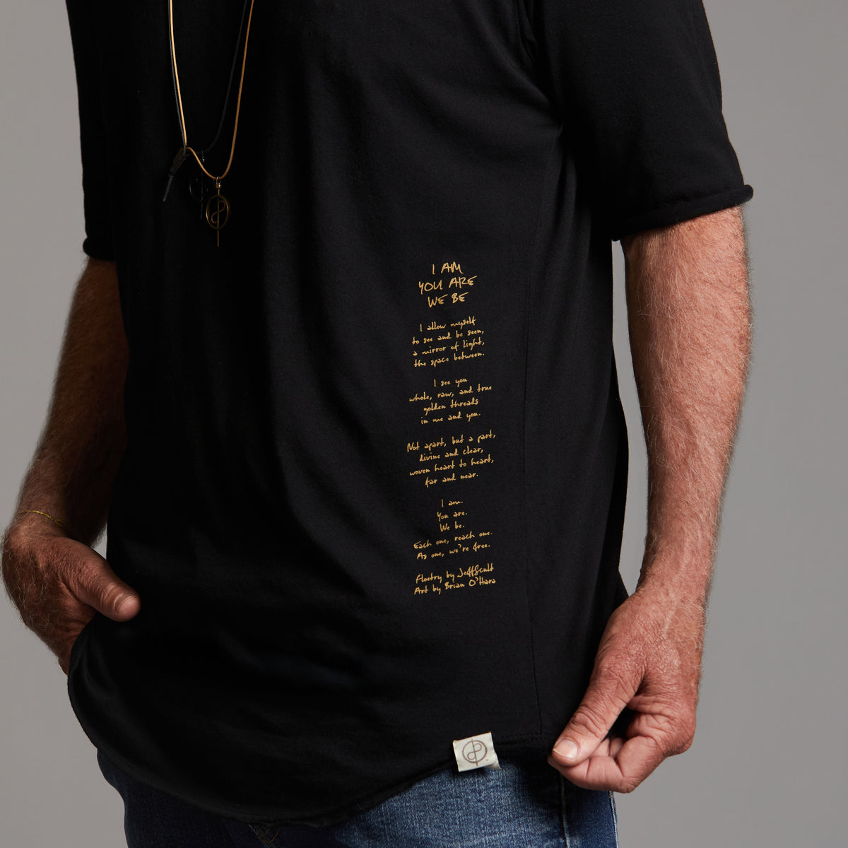 Man modeling a crew neck t shirt with gold graphics