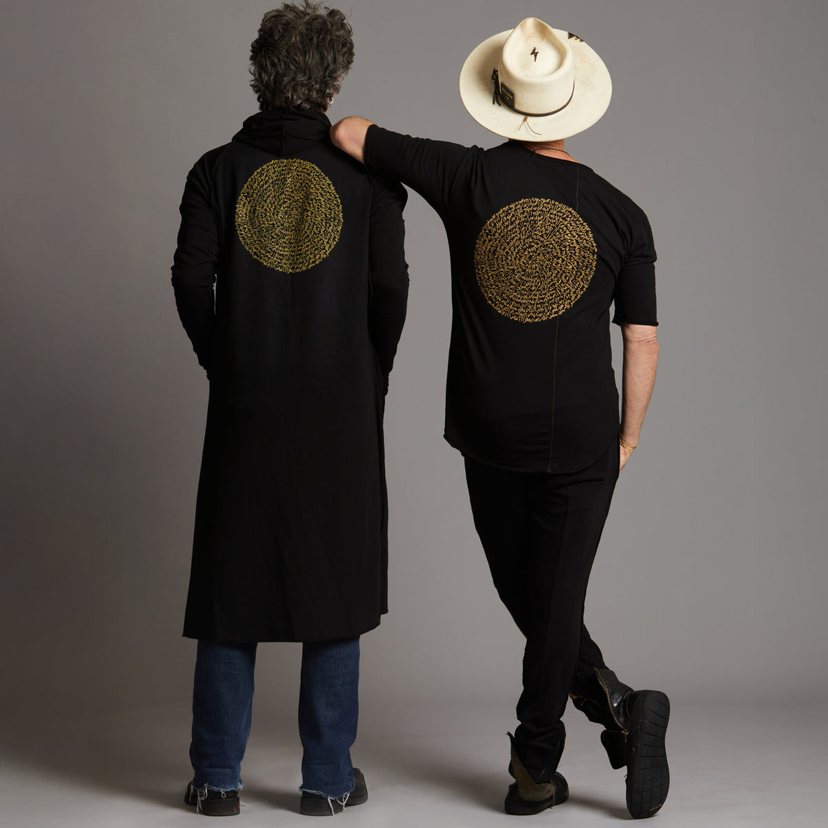 Two men modeling a crew neck t shirt and duster with gold graphics