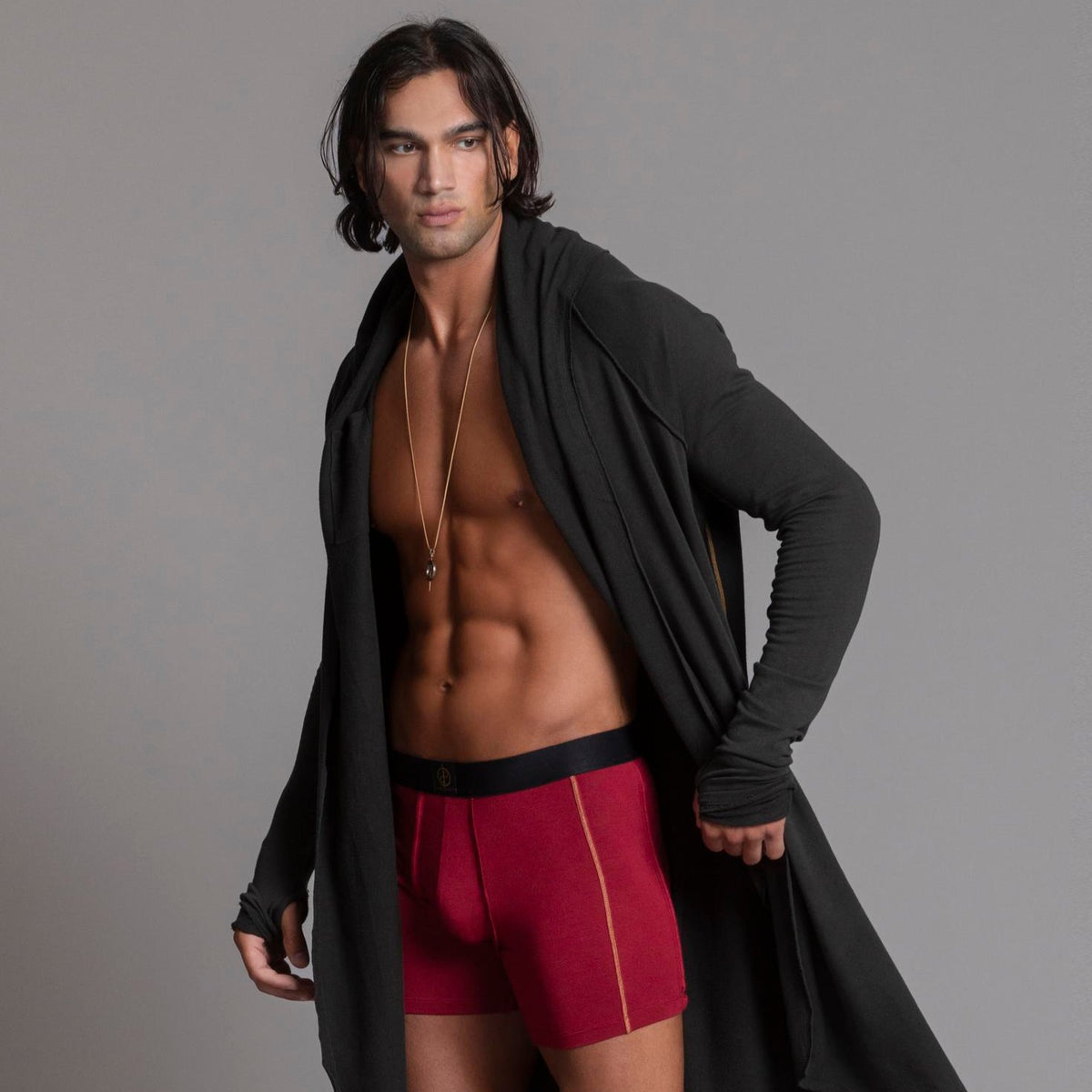 A man modeling the One Golden Thread Unders in Wine Red