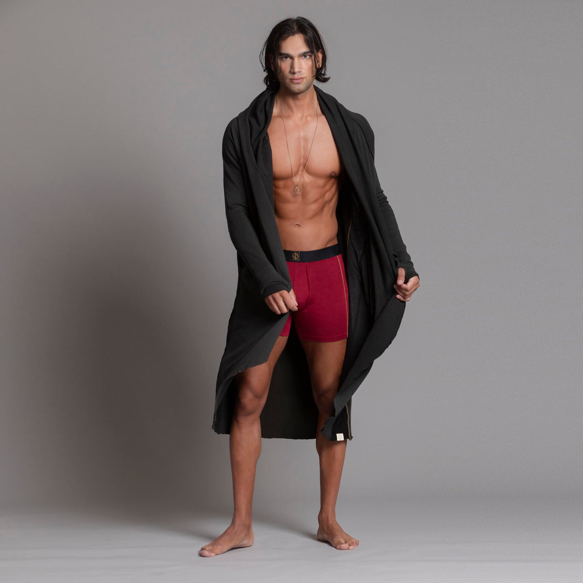 A man modeling the One Golden Thread Unders in Wine Red