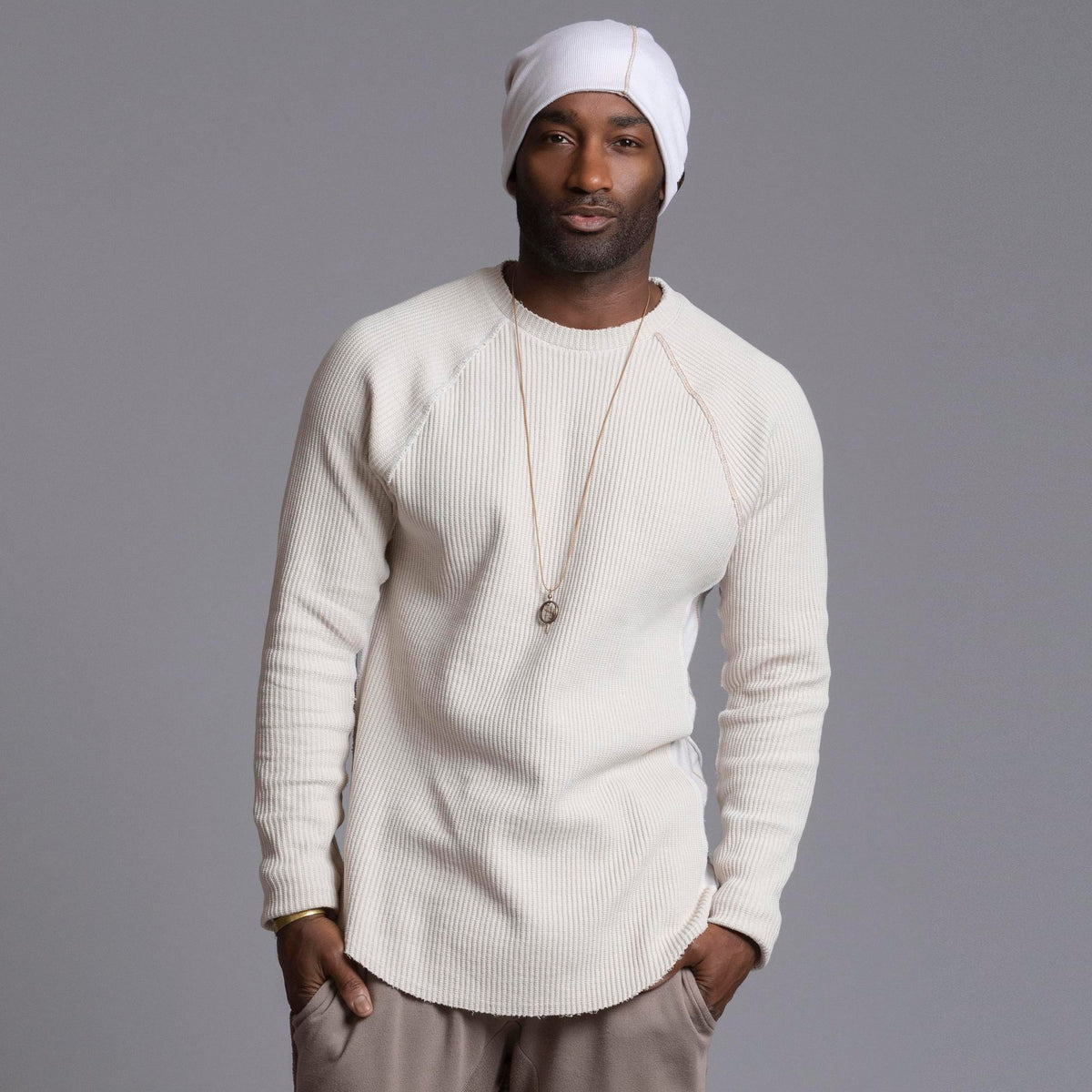 A man modeling a One Golden Thread Waffle Long Sleeve Raglan shirt in white stone