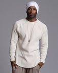 A man modeling a One Golden Thread Waffle Long Sleeve Raglan shirt in white stone