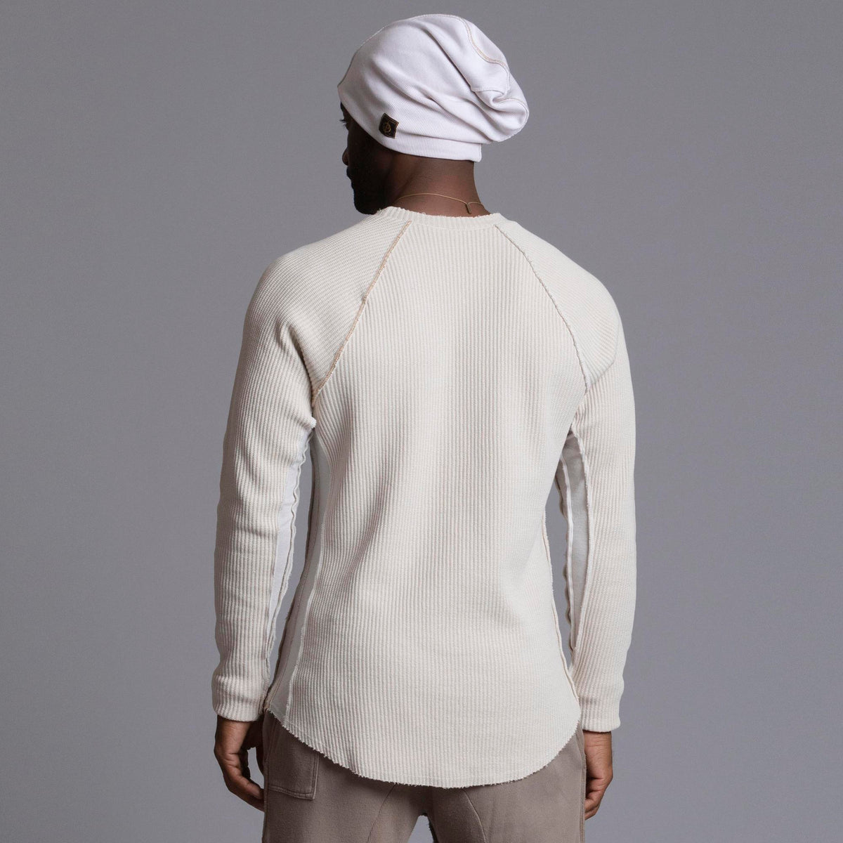 A man modeling a One Golden Thread Waffle Long Sleeve Raglan shirt in white stone