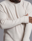 A man modeling a One Golden Thread Waffle Long Sleeve Raglan shirt in white stone