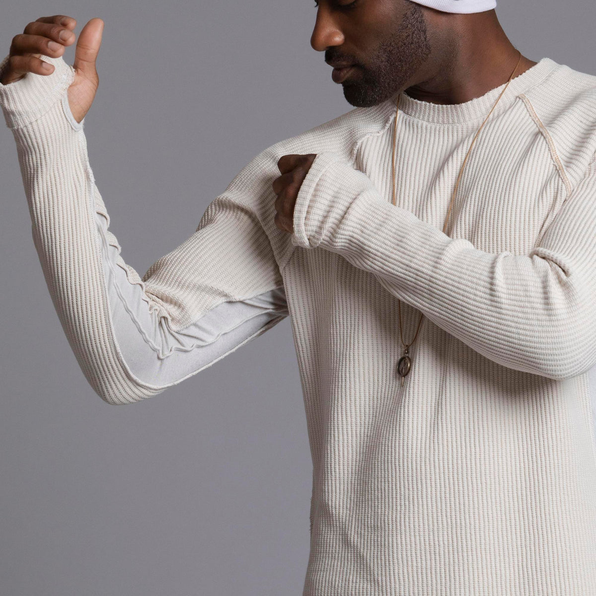 A man modeling a One Golden Thread Waffle Long Sleeve Raglan shirt in white stone