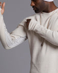 A man modeling a One Golden Thread Waffle Long Sleeve Raglan shirt in white stone
