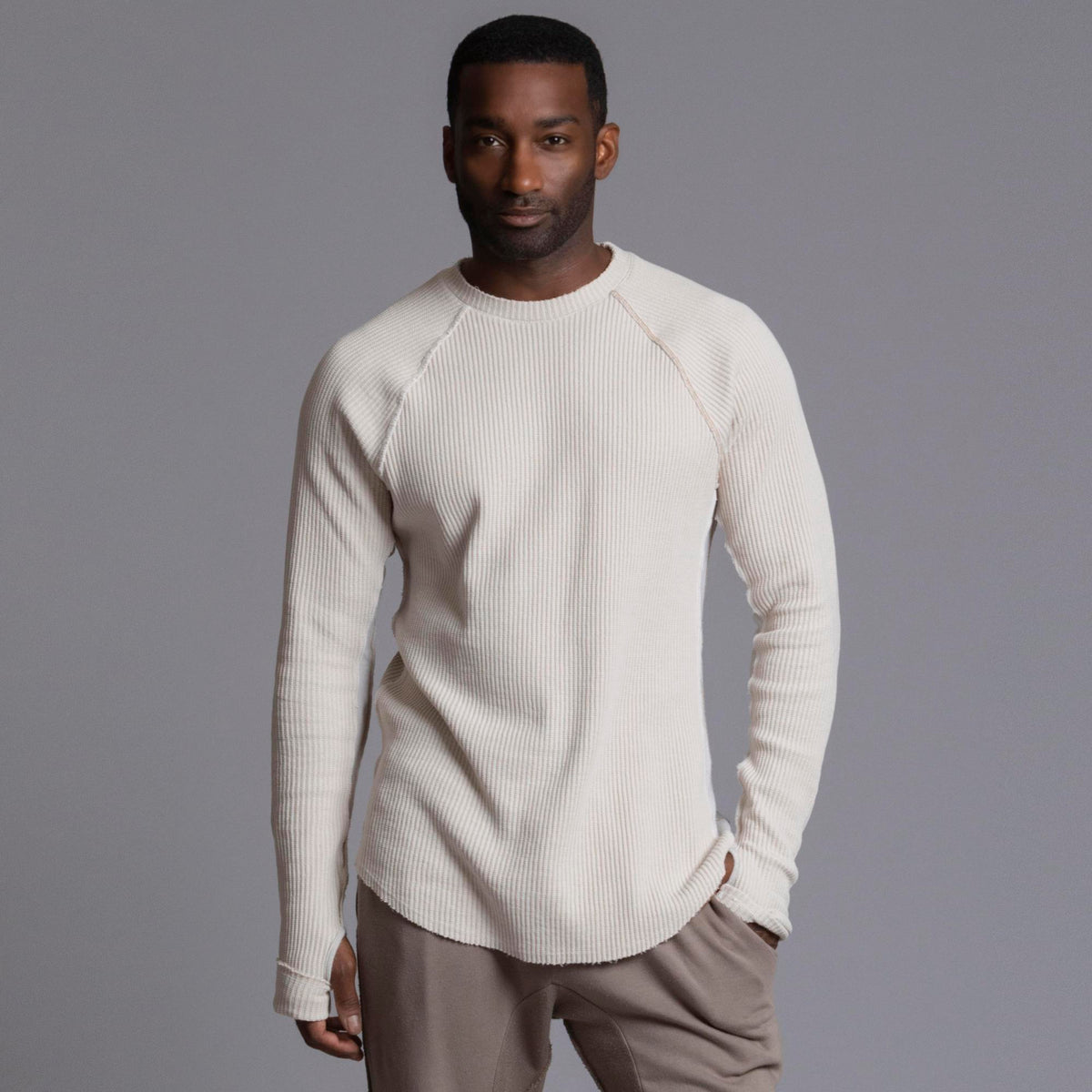 A man modeling a One Golden Thread Waffle Long Sleeve Raglan shirt in white stone
