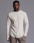 A man modeling a One Golden Thread Waffle Long Sleeve Raglan shirt in white stone