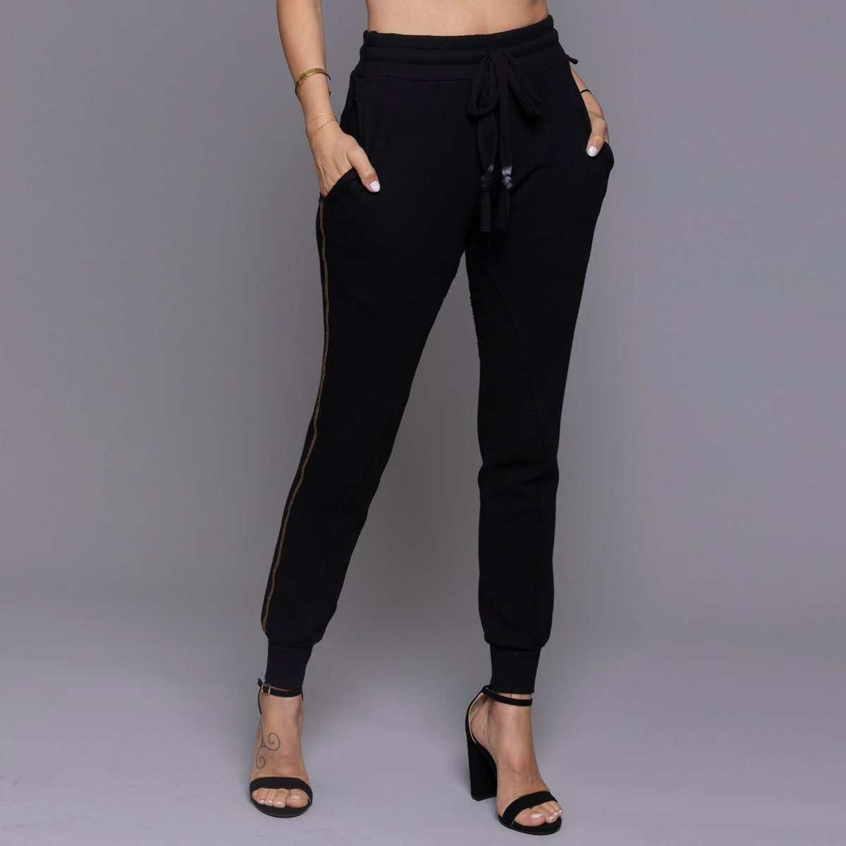 A woman modeling the One Golden Thread Jogga Pants in Black
