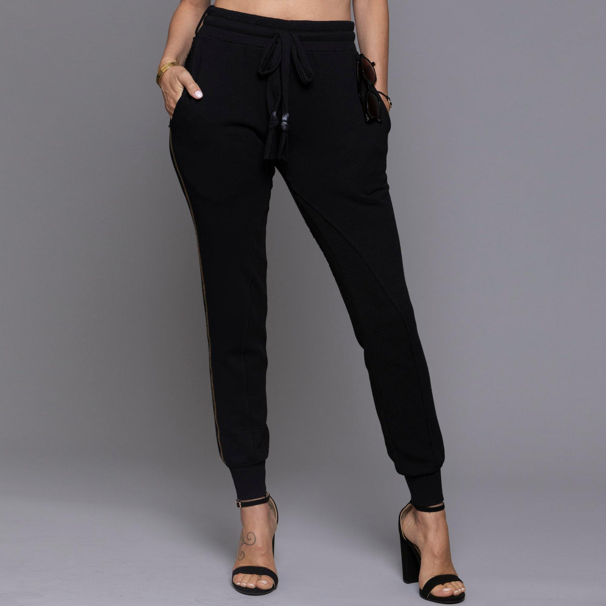 A woman modeling the One Golden Thread Jogga Pants in Black