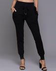 A woman modeling the One Golden Thread Jogga Pants in Black