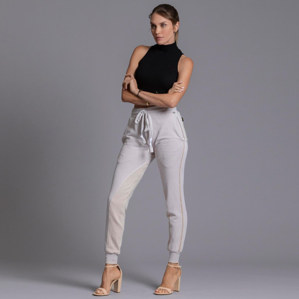 A woman modeling the One Golden Thread Jogga Pants in White Stone 