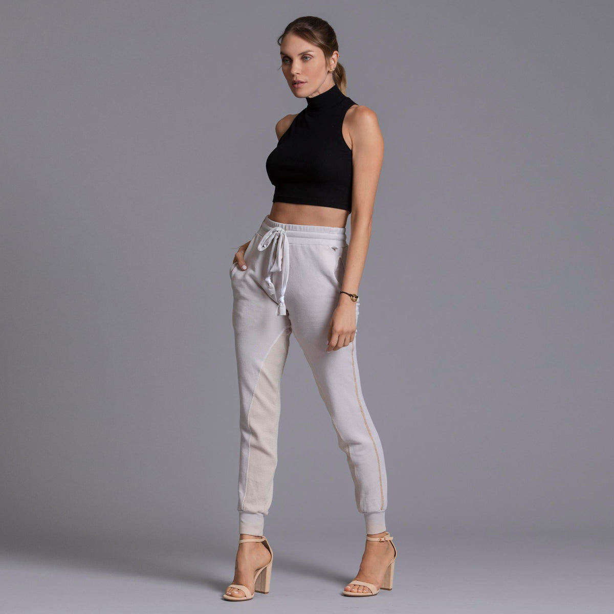 A woman modeling the One Golden Thread Jogga Pants in White Stone