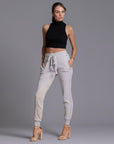 A woman modeling the One Golden Thread Jogga Pants in White Stone 