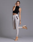 A woman modeling the One Golden Thread Jogga Pants in White Stone 