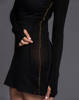 A woman modeling the One Golden Thread Reversible Little Black Dress