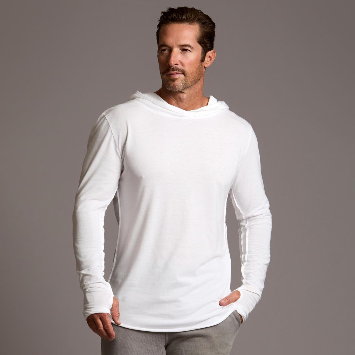 Man modeling white long-sleeve hooded tee
